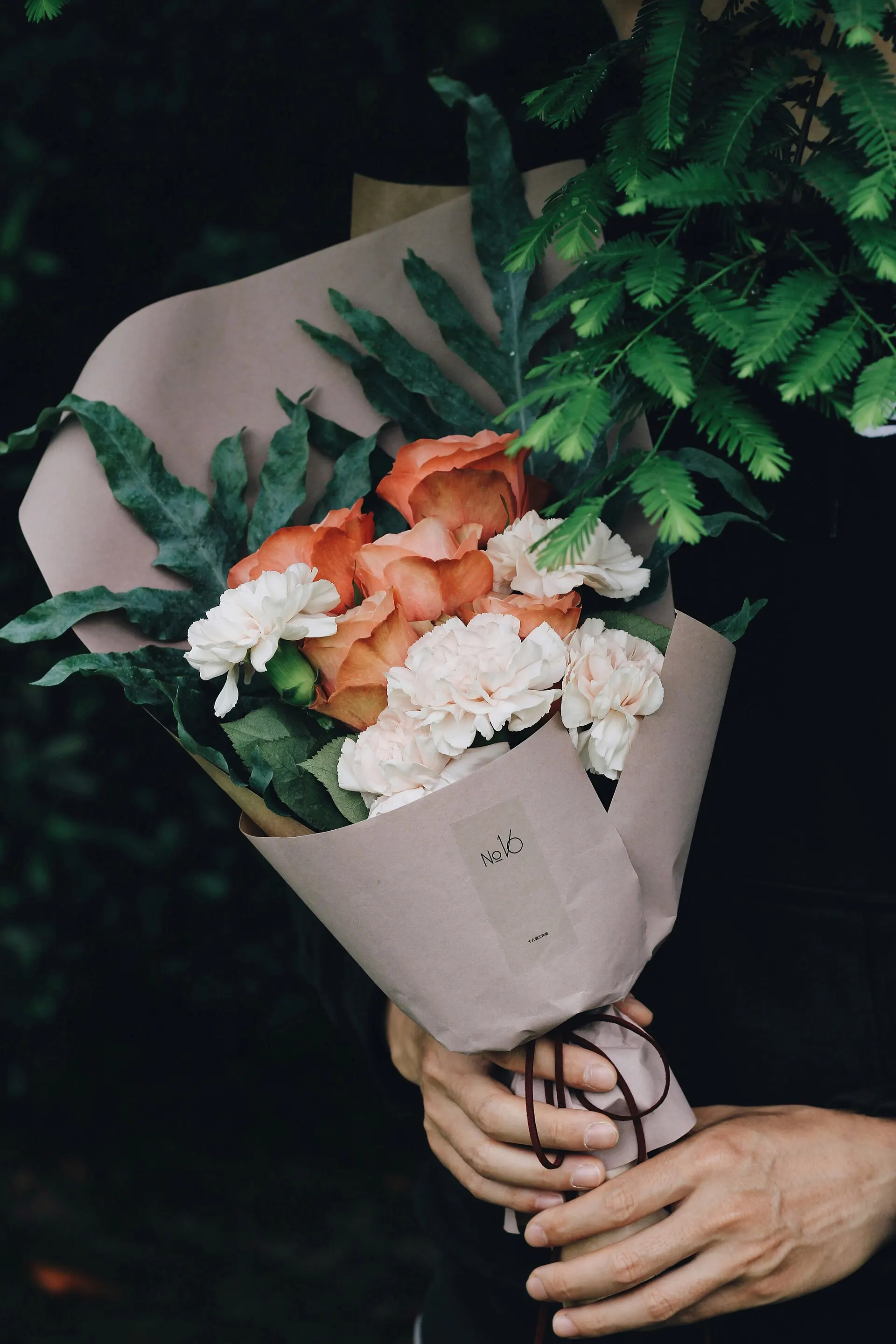 Un mazzo di rose e garofani avvolto nella carta
