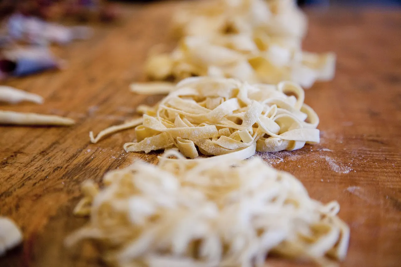 Pasta fresca tagliata a mano su un tagliere di legno